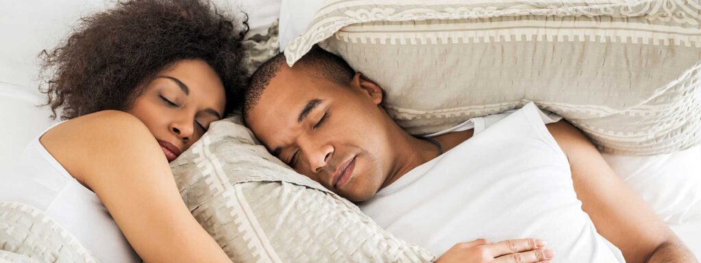 An African American couple sleeping without concern of tinnitus