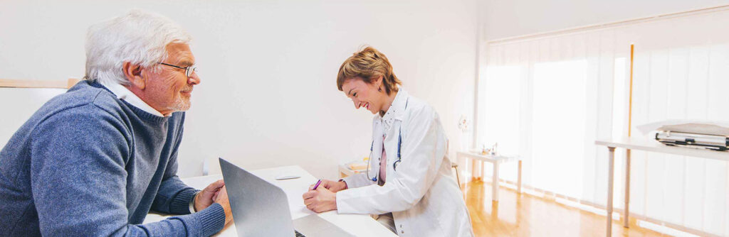 A female doctor helps a patient at the front desk